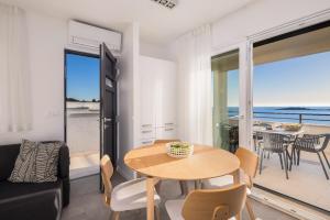 a living room with a table and chairs and a balcony at Villa Lavanda Deluxe in Rogoznica +39 photos