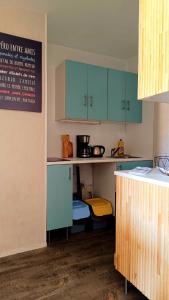 a small kitchen with blue cabinets and a counter at Appartement L'esprit marin in Villers-sur-Mer