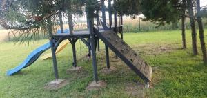 a playground with a slide in a park at Folwark Pod Bukowcem in Podzamcze