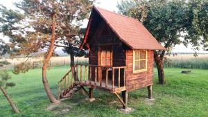 a small wooden house with a red roof at Folwark Pod Bukowcem in Podzamcze +35 photos