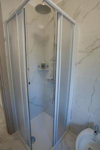 a shower with a glass door next to a toilet at Ca' di Sara in Domodossola