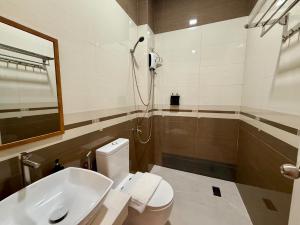 a bathroom with a shower and a toilet and a sink at MBC Hotel in Guinlajong +22 photos