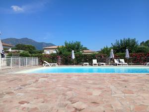 a swimming pool with chairs and umbrellas at Villa climatisée 4-6 pers avec piscine, terrasse & jardin - 2 min plage in Cervione