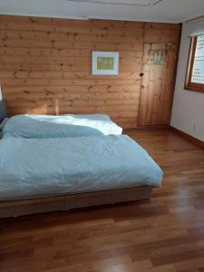 a bedroom with a bed and a wooden wall at Art Residency in Busan