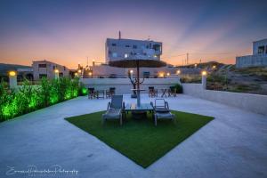 a patio with a table and chairs and an umbrella at Platsa Apartments in Megás Limniónas