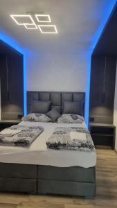 a bedroom with a bed in a blue room at Jacuzzi apartments Istočno Sarajevo in Sarajevo +21 photos