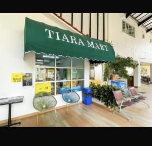 aarma manarmaarma store with chairs and a green umbrella at Tiara Homestay Desaru - Garden Pool View in Bandar Penawar