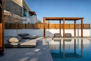 a swimming pool with two mattresses on the side of a house at Elements Villas in Lartos
