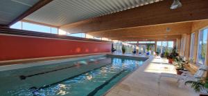 a swimming pool in a house with a large window at Ferienwohnung Ronja im Hause Bergland Altreichenau in Neureichenau