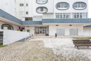 a building with a bench in front of it at studio world romer in Costa da Caparica