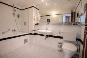 a white bathroom with a toilet and a sink at Hotel Attaché in Vienna
