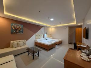 a large room with two beds and a couch at MBC Hotel in Guinlajong