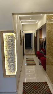 a hallway of a hotel with a red couch at Adel home in Kafr al Ishārah