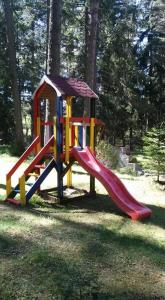 a playground with a slide in the grass at Вила Шишарка in Govedartsi