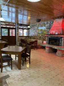 a restaurant with tables and chairs and a fireplace at Вила Шишарка in Govedartsi