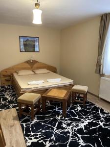 a bedroom with a bed and two chairs and a rug at Вила Шишарка in Govedartsi