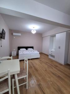 a large room with a bed and a table at Sunset Bliss Apartments in Sarandë