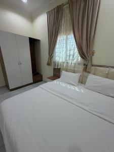 a large white bed in a bedroom with a window at شقق ذاعذاع النسيم المخدومة in Al Khuraymī