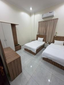 a hotel room with two beds and a heater at شقق ذاعذاع النسيم المخدومة in Al Khuraymī