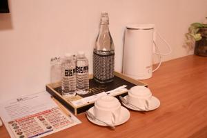 a tray with a bottle and cups on a table at MBC Hotel in Guinlajong