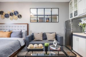 a living room with a blue couch and a glass table at Airport Haven Condotel - near Mactan-Cebu Airport 13 mins ride, Self Check-In, Wifi, Netflix, pool and Balcony view in Lapu Lapu City +101 photos