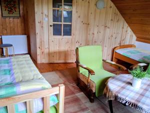 a room with two beds and a green chair at Dom Gaja in Ińsko