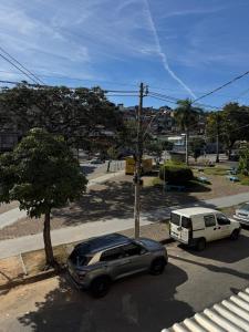 a car and a van parked in a parking lot at Apartamento individual in Ipatinga