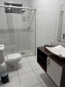 a bathroom with a shower and a toilet and a sink at Apartamento individual in Ipatinga +11 photos