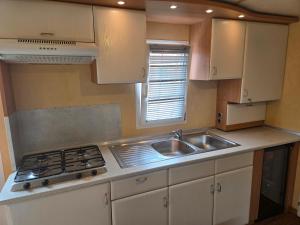a small kitchen with a sink and a stove at Kopićland HOMES in Marinci