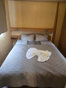 a bed with a robe laying on top of it at Kopićland HOMES in Marinci