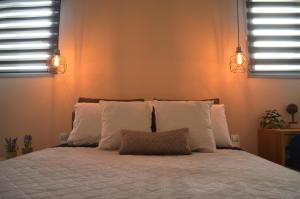 a bedroom with a bed with white pillows and two lights at Downtown apartment - Signature in Kamena Vourla