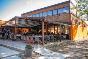 a restaurant with tables and chairs in front of a building at Kopićland HOMES in Marinci