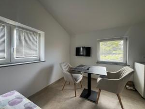 a room with a table and two chairs and two windows at Olive Garden Studio in Izola