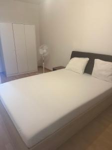 a large bed with white sheets and pillows at Basel Shared Apartment in Basel