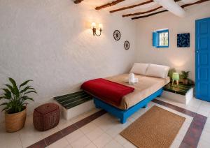 a bedroom with a bed with a red blanket at Caiat Lounge Refuge , Mountain Lodge near Akchour Waterfalls in Taghzoute