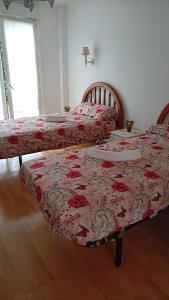 two beds in a room with red and white blankets at Ostatu ikaztegieta in Aldaba-chiqui