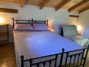 a bedroom with a large bed and two chairs at B&B PETITE PROVENCE Genova in Ceranesi