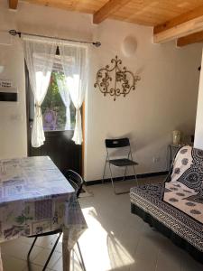 a room with a table and a bed and a window at B&B PETITE PROVENCE Genova in Ceranesi