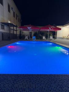a large blue swimming pool at night at Shergiron Plaza in Bukhara +14 photos