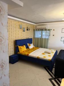 a bedroom with a blue bed with two pillows at Residence Singa in Abidjan