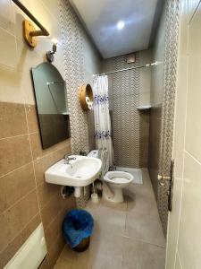a bathroom with a sink and a toilet and a mirror at Surf and Tribe in Tamraght Ouzdar