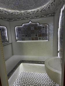 a white bathroom with a tub and a sink at Shergiron Plaza in Bukhara