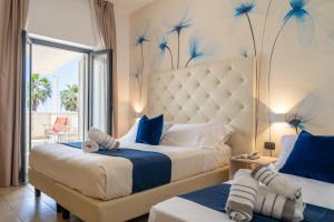 a bedroom with two beds with blue flowers on the wall at Hotel Tenda Rossa in Marina di Carrara +58 photos