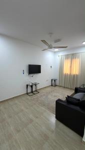 a living room with a couch and a flat screen tv at شقة صحلنوت in Salalah