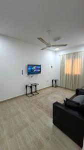 a living room with a couch and a flat screen tv at شقة صحلنوت in Salalah