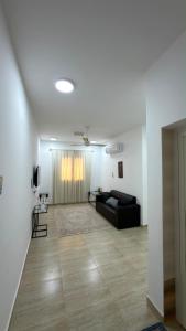 a living room with a black couch in a room at شقة صحلنوت in Salalah +2 photos