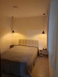 a bedroom with a bed and two lights on the wall at espaço completo só para você e seus familiares in Gravatá