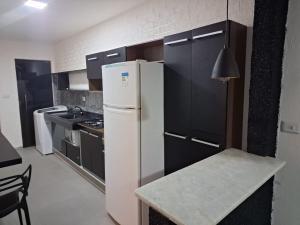a kitchen with a white refrigerator and a table at espaço completo só para você e seus familiares in Gravatá +9 photos
