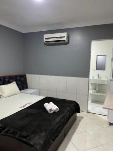 a bedroom with a bed with two towels on it at Hotel Flert Santana in São Paulo