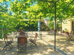 a group of tables and chairs in a park at Vila George in Eforie Sud